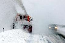 Pri pluženju snega pri Ravbarkomandi poledenel kos snega padel na minibus