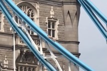 #video Na pol nag se je sončil na vrhu londonskega Tower Bridga in ustavil promet