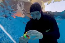 #video Nik Škrlec pod vodo z enim vdihom sestavil devet rubikovih kock 