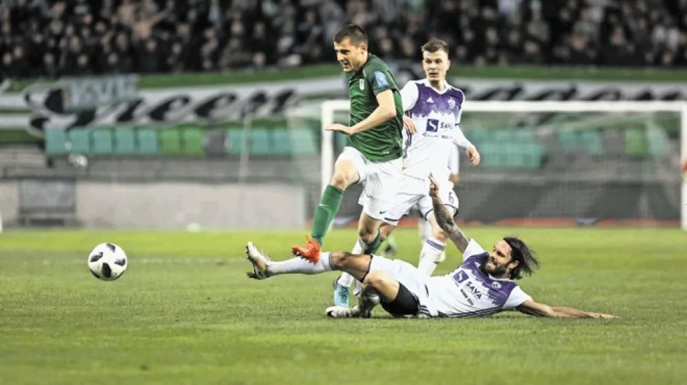 Vezist Olimpije Danijel Mi&scaron;kić (v zeleni majici) je bil nere&scaron;ljiva uganka za igralce Maribora na čelu z izku&scaron;enim Markom &Scaron;ulerjem (na tleh) in Aleksom Pihlerjem (v ozadju).