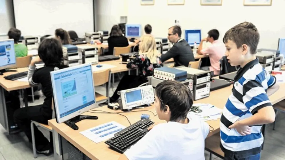 Učenec Val (na sliki desno) s prijateljem ob programiranju senzorja za svetlobo, vlažnost in temperaturo. Učenci z aspergerjevim sindromom na nekaterih področjih dosežejo mnogo več od vrstnikov.