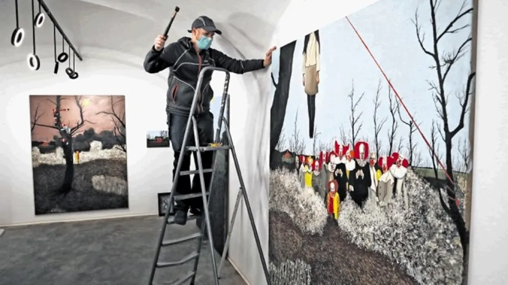 Slikar Matej Čepin v Galeriji Exarte v Židovski ulici v Ljubljani pri postavljanju svoje izložbene razstave Klovnonanija