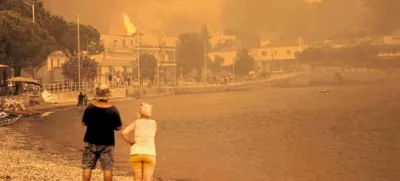 Podnebne spremembe oziroma vse višje povprečne temperature so tudi temeljni vzrok za čedalje pogostejše in hujše požare, kakršen je te dni zajel drugi največji grški otok Evio v Egejskem morju. Na fotografiji je plaža v mestecu Pefki kakih 200 kilometrov severovzhodno od Aten, kjer sta dim in pepel povsem prekrila nebo, tako da se sonce niti ne prebije več skozi. S turistično sezono je za letos konec, izseliti pa se bodo morali tudi domačini.