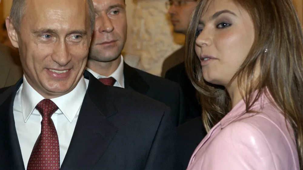 President Vladimir Putin, left, speaks with gymnast Alina Kabayeva as he hosts Russia's Olympic athletes at a Kremlin banquet in Moscow, Thursday, Nov. 4, 2004. Vladimir Putin on Thursday congratulated the country's Olympic team on their strong showing in Athens and stressed the importance of a healthy lifestyle. (AP Photo/ITAR-TASS, Presidential Press Service)