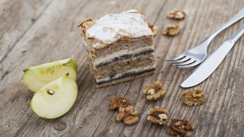Prekmurska hibanica over mura moving layered cake on wooden surface