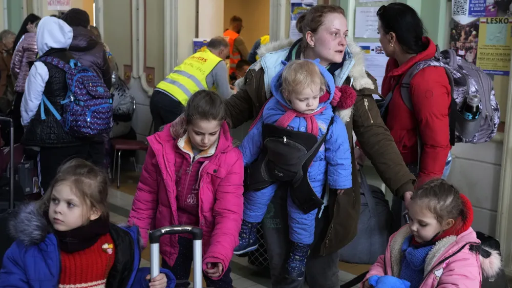 Ukrainian Marina Stadnik from Kramatosrk, waits with her four children at a train station in Przemysl, southeastern Poland, Monday, March 28, 2022. The more than month-old war has killed thousands and driven more than 10 million Ukrainians from their homes &mdash; including almost 4 million from their country. (AP Photo/Sergei Grits)