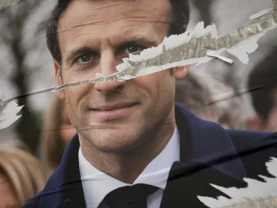 Torn presidential poster of French President Emmanuel Macron and centrist candidate for the reelection is on display in Paris, France, Wednesday, April 6, 2022. France's first round of the presidential election takes place on April 10, with a presidential runoff on April 24 if no candidate wins outright. (AP Photo/Francois Mori)