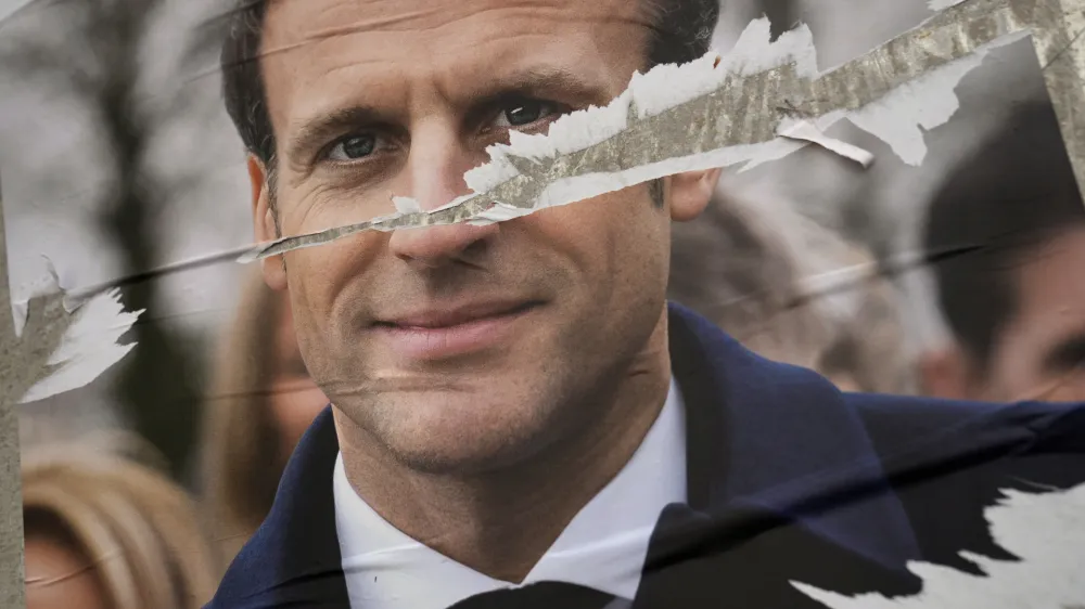 Torn presidential poster of French President Emmanuel Macron and centrist candidate for the reelection is on display in Paris, France, Wednesday, April 6, 2022. France's first round of the presidential election takes place on April 10, with a presidential runoff on April 24 if no candidate wins outright. (AP Photo/Francois Mori)