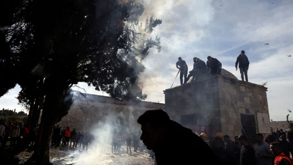 Palestinians put out a fire following a clash with Israeli security forces at the compound that houses Al-Aqsa Mosque, known to Muslims as Noble Sanctuary and to Jews as Temple Mount, in Jerusalem's Old City April 22, 2022. REUTERS/Ammar Awad   TPX IMAGES OF THE DAY