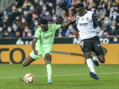 Valencia's Mouctar Diakhaby, right, vies for the ball with Athletic Bilbao's Inaki Williams during a Spanish Copa del Rey semifinal second leg soccer match between Valencia and Athletic Bilbao at the Mestalla stadium in Valencia, Spain, Wednesday, March 2, 2022. (AP Photo/Alberto Saiz)