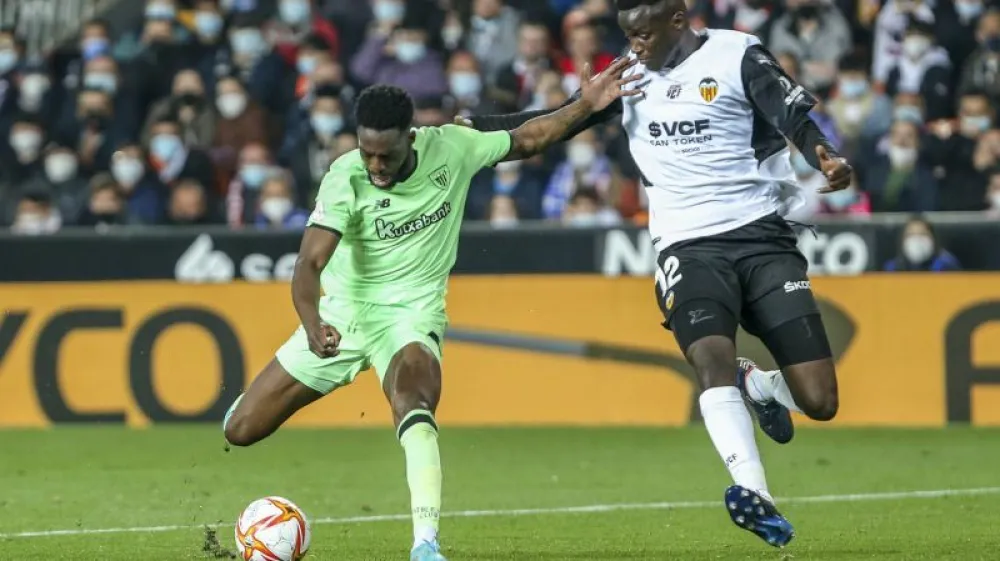 Valencia's Mouctar Diakhaby, right, vies for the ball with Athletic Bilbao's Inaki Williams during a Spanish Copa del Rey semifinal second leg soccer match between Valencia and Athletic Bilbao at the Mestalla stadium in Valencia, Spain, Wednesday, March 2, 2022. (AP Photo/Alberto Saiz)