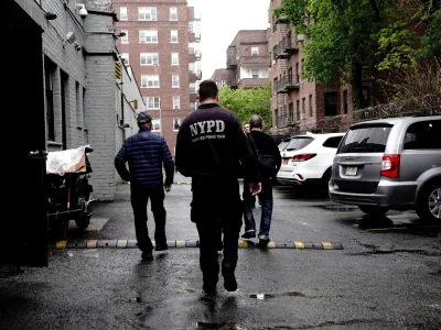 Employees of Great Wall, a Chinese restaurant which employed food delivery courier Zhiwen Yan, a 45 year old Chinese immigrant fatally shot and killed while working on April 30, lead officers of the New York City Police Department (NYPD) into the parking lot behind the restaurant in Forest Hills, a neighborhood in the Queens borough of New York City, U.S., May 2, 2022. REUTERS/Bing Guan
