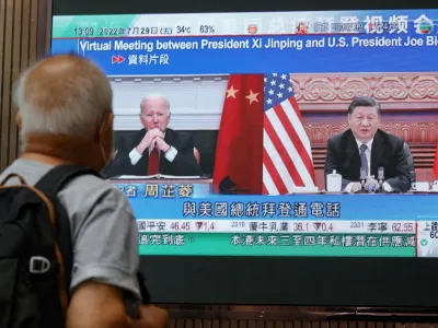 A screen displays images of Chinese President Xi Jinping and U.S. President Joe&nbsp;Biden, while broadcasting news about their recent call at a shopping mall in Hong Kong, China, July 29, 2022. REUTERS/Tyrone Siu