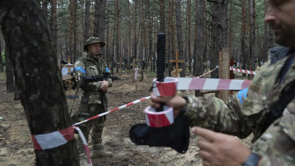 Oleg Kotenko, the Commissioner for Issues of Missing Persons under Special Circumstances looks at the unidentified graves of civilians and Ukrainian soldiers in the recently retaken area of Izium, Ukraine, Thursday, Sept. 15, 2022 who had been killed by Russian forces near the beginning of the war. A mass grave of Ukrainian&nbsp;soldiers and unknown buried civilians was found in the forest of recently recaptured city of&nbsp;Izium. (AP Photo/Evgeniy Maloletka)