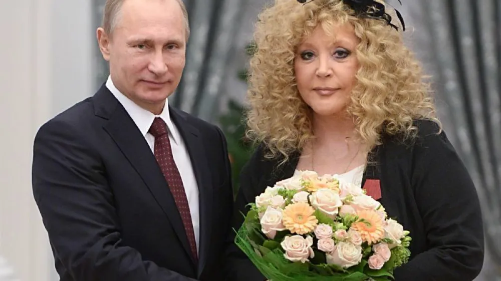 FILE - Russian President Vladimir Putin, left, and Russian pop singer Alla Pugacheva pose for a photo during an awards ceremony in Moscow's Kremlin in Moscow, Russia, Monday, Dec. 22, 2014. Iconic Russian singer Alla Pugacheva, hugely popular since Soviet times, says she wants to be placed on Russia's foreign agents list in solidarity with her husband who has been designated as one. The statement by Pugacheva on Instagram on Sunday is a notable slap from a prominent figure at Russian authorities, who have stifled dissent in recent years. (Alexei Druzhinin, Sputnik, Kremlin Pool Photo via AP, File)