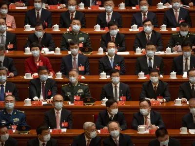 Delegates wearing face masks sit before the opening session of the 20th National Congress of China's ruling Communist Party in Beijing, China, Sunday, Oct. 16, 2022. As China's ruling Communist Party holds a major congress this week, many Beijing residents are wondering if the end of the meeting will bring any easing of China's draconian "zero-COVID" policies that are disrupting lives and the economy. (AP Photo/Mark Schiefelbein)