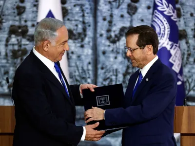 Israel President Isaac Herzog hands Benjamin Netanyahu the mandate to form a new government following the victory of the former premier's right-wing alliance in this month's election at the President's residency in Jerusalem November 13, 2022. REUTERS/Ronen Zvulun   TPX IMAGES OF THE DAY