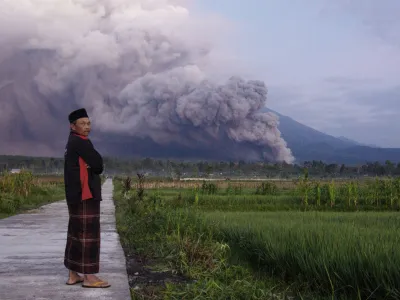 A man looks on as Mount Semeru releases volcanic materials during an eruption on Sunday, Dec. 4, 2022 in Lumajang, East java, Indonesia. Indonesia's highest volcano on the country's most densely populated island of Java erupted Sunday. (AP Photo)