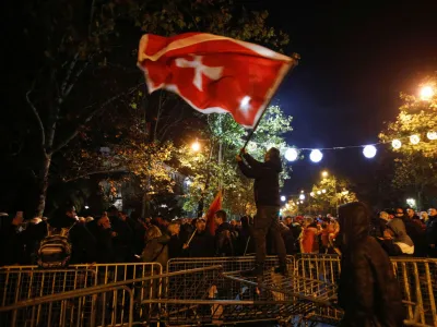 A protestor waves a flag on top of the breached barrier during a protest against the adoption of a law to limit presidential powers in Podgorica, Montenegro, December 12, 2022. REUTERS/Stevo Vasiljevic