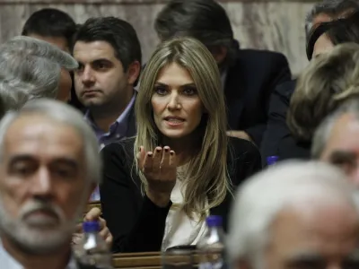 Socialist lawmaker Eva Kaili, center, chats prior the speech of Greek prime minister George Papandreou to his Socialist lawmakers members of parliament, in Athens, Thursday, Nov. 3, 2011 Papandreou has called a confidence vote on his government for Friday night, and his majority was reduced to the bare minimum 151 when Socialist lawmaker Eva Kaili said she would not vote in favor. (AP Photo/Petros Giannakouris)