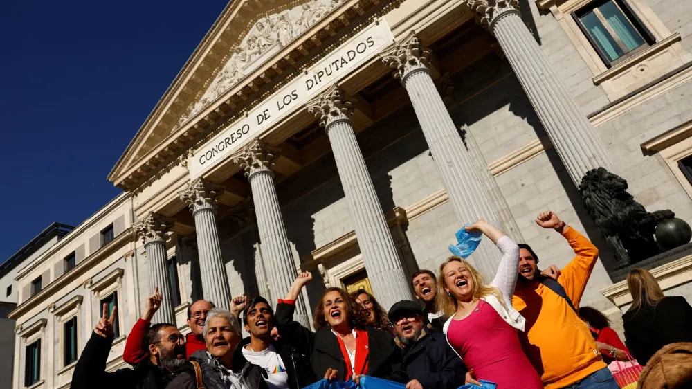 LGBT activists celebrate after the final approval of a law that will make it easier for people to self-identify as transgender, outside Spain's Parliament in Madrid, Spain, February 16, 2023. REUTERS/Susana Vera