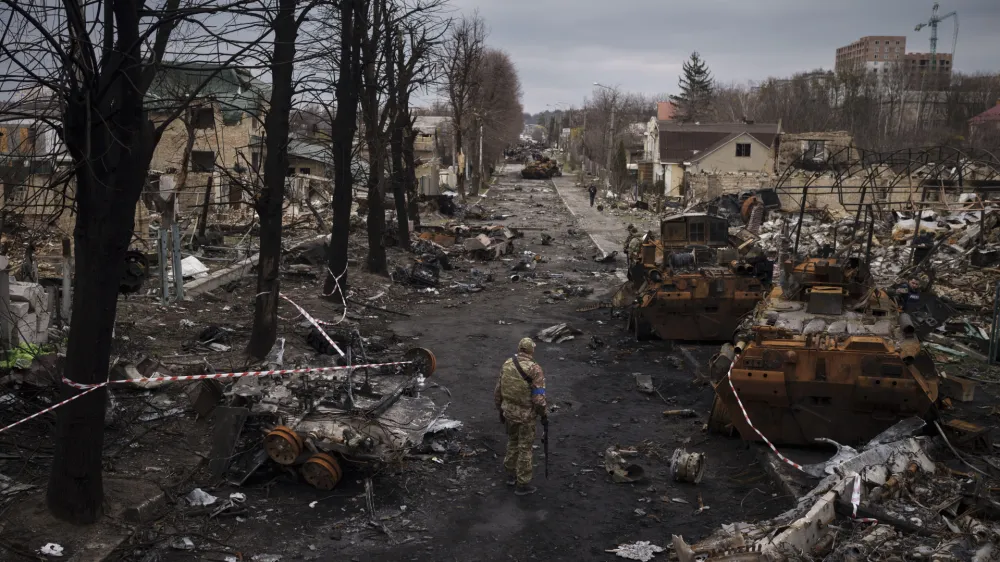 A Ukrainian serviceman walks amid destroyed Russian tanks in Bucha, on the outskirts of Kyiv, Ukraine, Wednesday, April 6, 2022. (AP Photo/Felipe Dana)