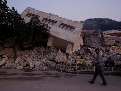 FILE PHOTO: FILE PHOTO: A man walks by a collapsed building and rubble, in the aftermath of a deadly earthquake, in Antakya, Hatay province, Turkey, February 21, 2023. REUTERS/Clodagh Kilcoyne/File Photo/File Photo