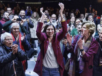 Elly Schlein, center, gestures at the headquarters of her electoral committee, after the announcement of the partial results of the Democratic Party primaries in Rome, Italy, Sunday, Feb. 26, 2023. Schlein, a 37-year-old U.S.-Italian national and longtime left-wing political operative, has defied polls to become the first woman to head Italy's opposition Democratic Party. (Roberto Monaldo/LaPresse via AP)