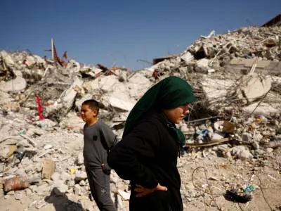 Fatmagul Arslan, 19-year-old, and her brother Saltuk, 9-year-old, stand as they visit the remains of their home, where they were trapped for five days with their parents and sister until being rescued, in the aftermath of a deadly earthquake in Nurdagi, Turkey, March 4, 2023. REUTERS/Susana Vera   TPX IMAGES OF THE DAY