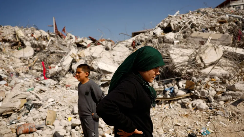 Fatmagul Arslan, 19-year-old, and her brother Saltuk, 9-year-old, stand as they visit the remains of their home, where they were trapped for five days with their parents and sister until being rescued, in the aftermath of a deadly earthquake in Nurdagi, Turkey, March 4, 2023. REUTERS/Susana Vera   TPX IMAGES OF THE DAY