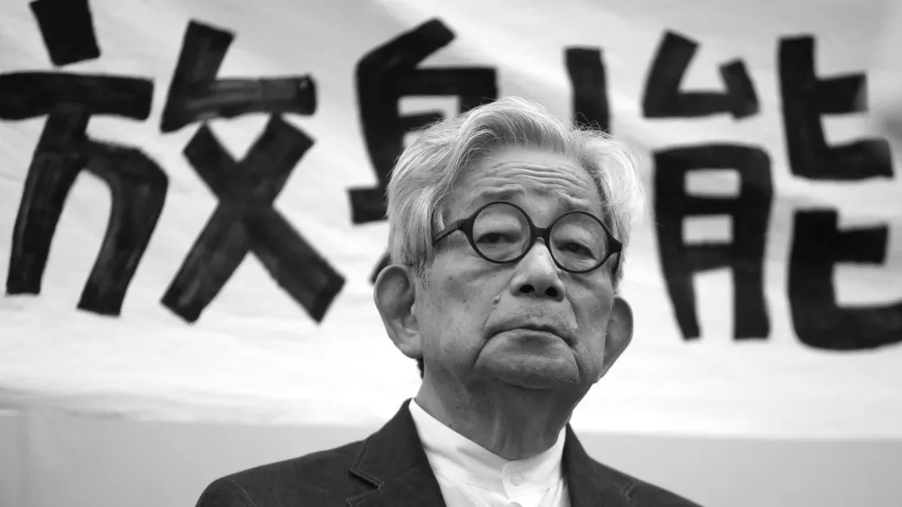 FILE PHOTO: Japanese Nobel literature prize winner Kenzaburo Oe sits in front of a banner reading "radiation" during an anti-nuclear gathering in Tokyo, Japan September 19, 2011. REUTERS/Yuriko Nakao/File Photo