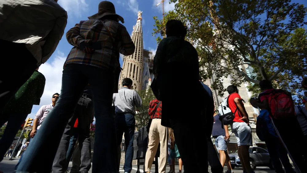 People stand outside the Sagrada Familia cathedral in Barcelona, Spain, October 11, 2017. REUTERS/Ivan Alvarado - RC1424C53A60