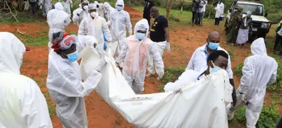 Forensic experts and homicide detectives carry the bodies of suspected members of a Christian cult named as Good News International Church, who believed they would go to heaven if they starved themselves to death, after their remains were exhumed from their graves in Shakahola forest of Kilifi county, Kenya April 22, 2023. REUTERS/Stringer