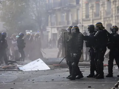 Riot police officers advance among debris during a demonstration, Monday, May 1, 2023 in Paris. Across France, thousands marched in what unions hope are the country's biggest May Day demonstrations in years, mobilized against President Emmanuel Macron's recent move to raise the retirement age from 62 to 64. (AP Photo/Aurelien Morissard)