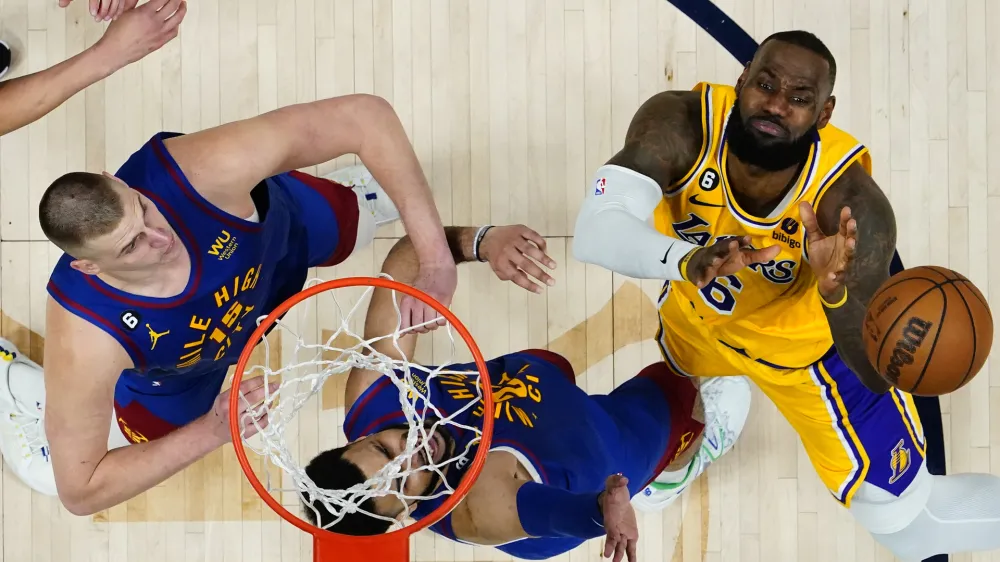 Los Angeles Lakers forward LeBron James (6) loses the ball as Denver Nuggets center Nikola Jokic (15) and Jamal Murray defendduring the second half of Game 1 of the NBA basketball Western Conference Finals series, Tuesday, May 16, 2023, in Denver. The Nuggets defeated the Lakers 132-126. (AP Photo/Jack Dempsey)