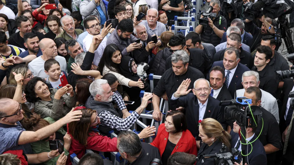 Turkish CHP party leader and Nation Alliance's presidential candidate Kemal Kilicdaroglu, right, waves to supporters after he casted his ballot at a polling station in Ankara, Turkey, Sunday, May 28, 2023. Voters in Turkey returned to the polls Sunday to decide whether the country's longtime leader, Erdogan, stretches his increasingly authoritarian rule into a third decade or is unseated by a challenger who has promised to restore a more democratic society. (Ugur Yildirim/Dia Images via AP)