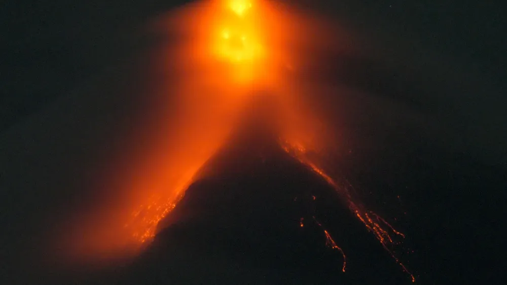 Mayon volcano belches red-hot emissions down it's slope as seen from Legaspi, Albay province, northeastern Philippines, Sunday, June 11, 2023. Albay was placed under a state of calamity last week to allow more rapid disbursement of emergency funds in case a major eruption unfolds. (AP Photo/Aaron Favila)