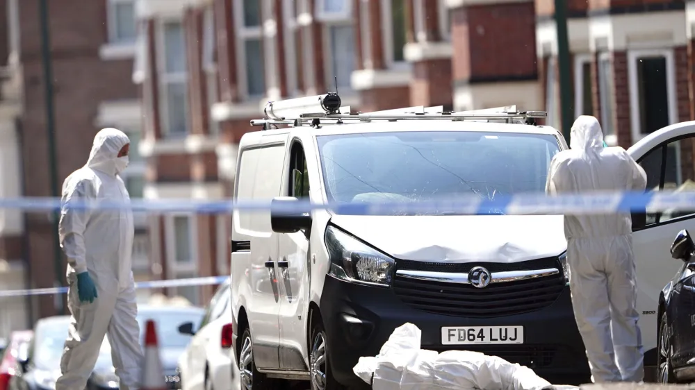 Police forensics officers search a white van on the corner of Maples Street and Bentinck Road in Nottingham, as three people have been found dead in the city in what police described as a "horrific and tragic incident". A 31-year-old man has been arrested on suspicion of murder after two people were found dead in the street in Ilkeston Road just after 4am on Tuesday. A third man was found dead in Magdala Road, Nottinghamshire Police said. Another three people are in hospital after someone tried to run them over in a van in Milton Street, in what police believe was a connected incident, Tuesday June 13, 2023. (Zac Goodwin/PA via AP)