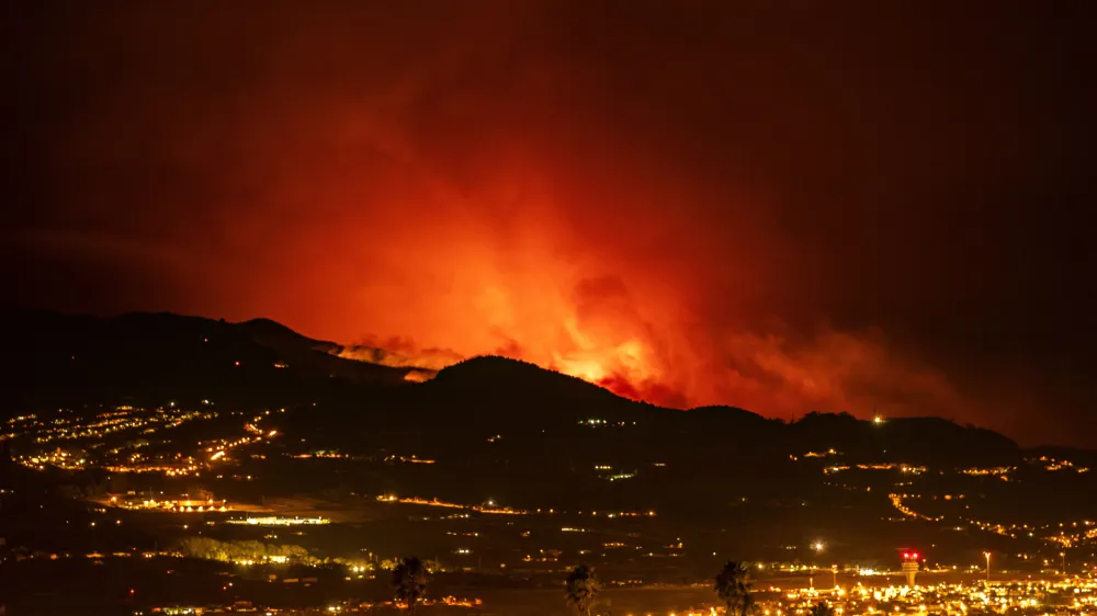 Flares are seen on the horizon as the fire advances through the forest toward the town of La Laguna and Los Rodeos airport in Tenerife, Canary Islands, Spain on Saturday, Aug. 19, 2023. Firefighters have battled through the night to try to bring under control the worst wildfire in decades on the Spanish Canary Island of Tenerife, a major tourist destination. The fire in the north of the island started Tuesday night and has forced the evacuation or confinement of nearly 8,000 people. Regional officials say Friday's efforts will be crucial in containing the fire. (AP Photo/Arturo Rodriguez)