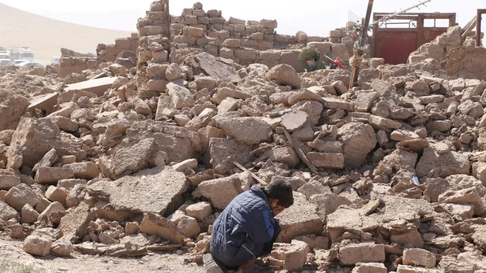 A boy cries as he sits next to debris, in the aftermath of an earthquake in the district of Zinda Jan, in Herat, Afghanistan, October 8, 2023. REUTERS/Stringer NO RESALES. NO ARCHIVES   TPX IMAGES OF THE DAY