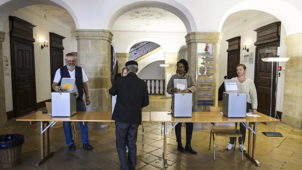 A man casts his ballot during Swiss federal elections in Delemont, Switzerland, Sunday, Oct. 22, 2023. Swiss voters are casting final ballots to choose their next legislature. Polls point to a rebound Sunday for right-wing populist and Socialist parties, while Greens are expected to lose ground compared to the last such election four years ago. (Jean-Christophe Bott/Keystone via AP)