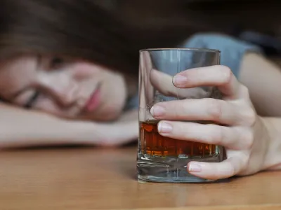 Drunk female with a glass of whiskey