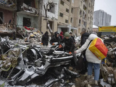 Volunteers and residents clear debris of an apartment building destroyed after Russian attack in Kyiv, Ukraine, Wednesday, Jan. 3, 2024. (AP Photo/Efrem Lukatsky)