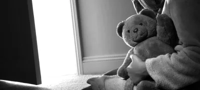 BTA0N2 Young girl sitting holding a teddy bear, back view.<br>spolna zloraba otroci otrok