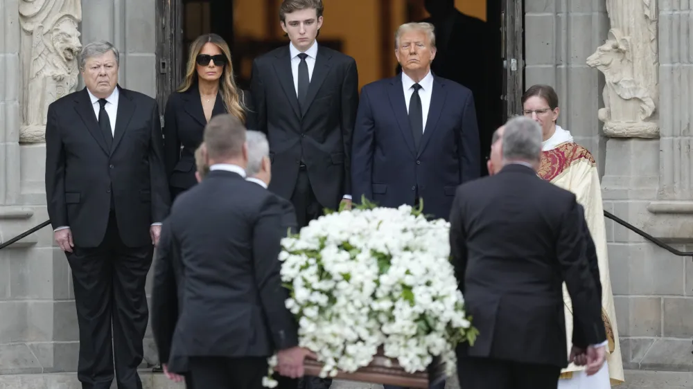 Former President Donald Trump, center right, stands with his wife Melania, second left, their son Barron, center left, and father-in-law Viktor Knavs, as the coffin carrying the remains of Amalija Knavs, the former first lady's mother, is carried into the Church of Bethesda-by-the-Sea for her funeral, in Palm Beach, Fla., Thursday, Jan. 18, 2024. (AP Photo/Rebecca Blackwell)