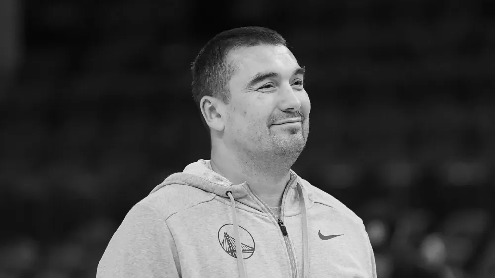 Golden State Warriors assistant coach Dejan Milojevic watches players warm up before an NBA preseason basketball game against the Denver Nuggets in San Francisco, Friday, Oct. 14, 2022. Warriors assistant coach Dejan Milojević, a mentor to two-time NBA MVP Nikola Jokic and a former star player in his native Serbia, died Wednesday, Jan. 17, 2024, after suffering a heart attack, the team announced. Milojević, part of the staff that helped the Warriors win the 2022 NBA championship, was 46. (AP Photo/Jeff Chiu)