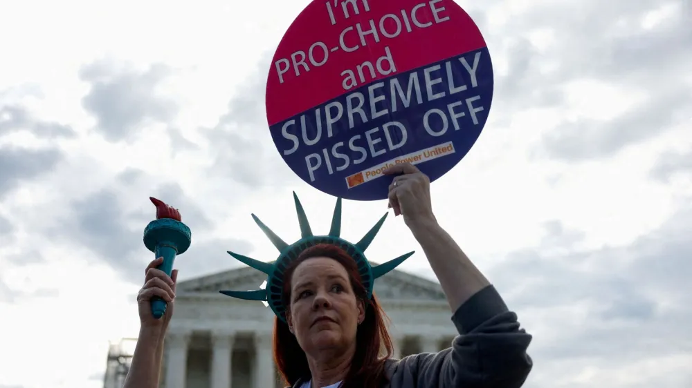 Laurie Woodward Garcia from Tampa, Florida, holds a placard during a "die-in" protest in support of reproductive rights and emergency abortion care, as Supreme Court justices hear oral arguments over the legality of Idaho's Republican-backed, near-total abortion ban in medical-emergency situations, in Washington, U.S., April 24, 2024. REUTERS/Evelyn Hockstein   TPX IMAGES OF THE DAY