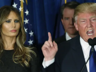 Republican U.S. presidential candidate Donald Trump gestures during his victory speech as his wife Melania, looks on at his 2016 New Hampshire presidential primary night rally in Manchester, New Hampshire February 9, 2016. REUTERS/Jim Bourg - RTX269FU