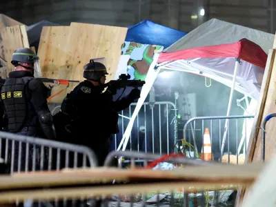 Law enforcement officers stand as protesters supporting Palestinians in Gaza gather at an encampment at the University of California Los Angeles (UCLA), amid the conflict between Israel and the Palestinian Islamist group Hamas, in Los Angeles, California, U.S., May 2, 2024. REUTERS/Mike Blake