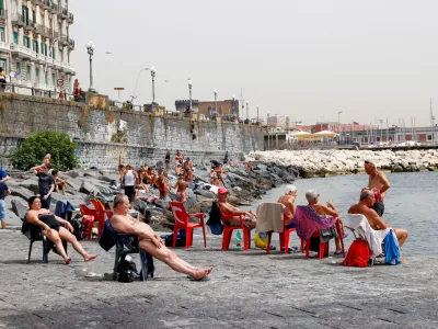 People sunbathe at the beach during a heatwave in Naples, Italy, June 21, 2024. REUTERS/Ciro De Luca